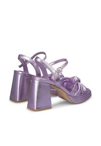 Paarse metallic hoge hakken sandalen met een geknotte voorkantdetail, enkelbandjes en chunky vierkante hakken. Gladde glanzende textuur.