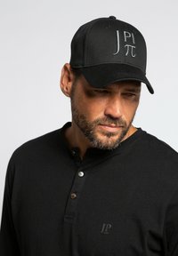 Schwarze Kappe mit besticktem "JP π"-Logo, gebogenem Schirm und Sechs-Panel-Design. Getragen mit einem schwarzen Langarm-Henley-Shirt mit Knopf-Details.