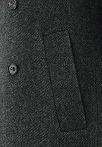 Nahaufnahme eines dunkelgrauen, strukturierten Mantelstoffs mit einem Knopf und einer horizontalen Leistentasche.