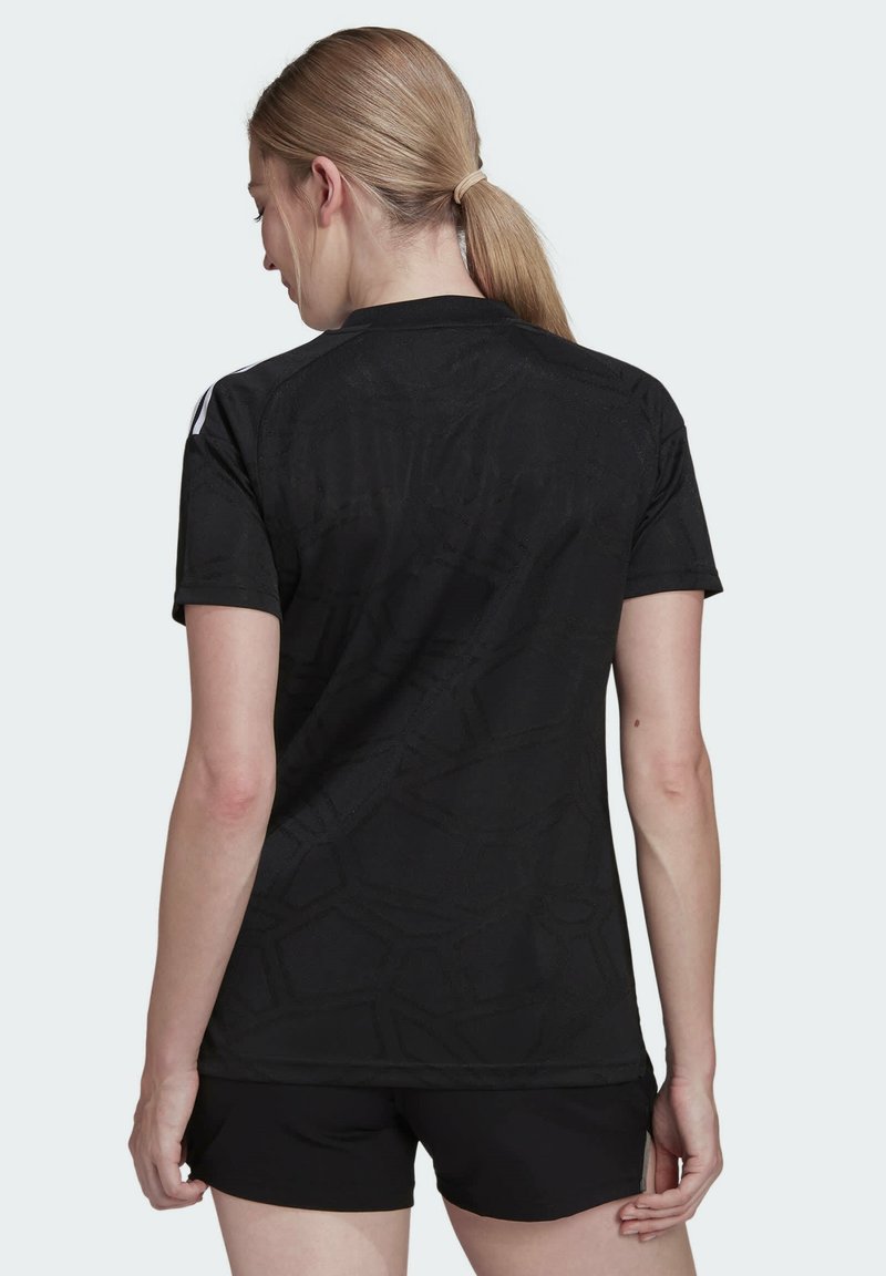 Camisa deportiva negra con un patrón geométrico texturizado, mangas cortas y dobladillo curvado. Presenta un brillo sutil y un diseño minimalista.