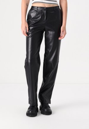 Black faux leather pants with a high waist, straight-leg design, front pockets, and creased details, worn with black platform shoes.