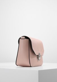 Růžová kožená taška s pevnou strukturou, klopovým zavíráním zdobeným stříbrným kováním a černým lemováním okrajů.