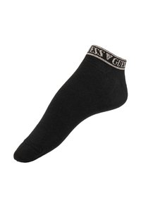 Chaussette noire jusqu'à la cheville en tissu doux, avec un haut côtelé contrastant portant le logo "Guess" en beige. Texture lisse et design sans couture.
