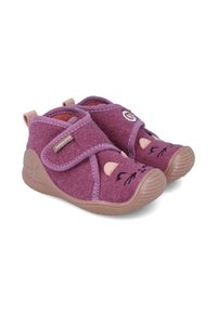 Zapatos de niño pequeños en color púrpura con diseño de cara de gato, correas de Velcro y suelas de goma flexibles, colocados uno al lado del otro sobre un fondo blanco.