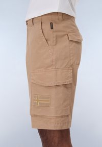 Beige cargo shorts med en blød tekstur, der har flere lommer, et syet flagdesign og en afslappet pasform.