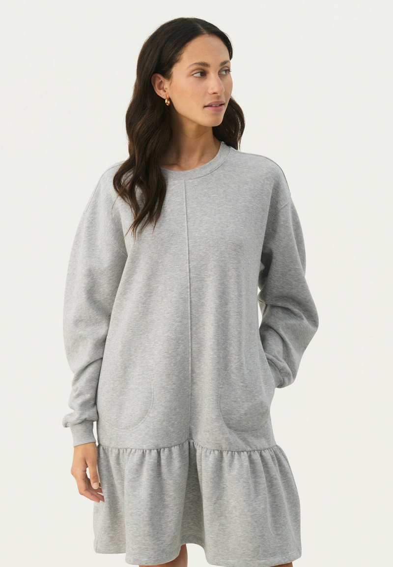 Graues Sweatshirt-Kleid mit langen Ärmeln, rundem Ausschnitt, seitlichen Taschen und gestuften, rüschierten Saum. Aus weicher, strukturiertem Stoff gefertigt.