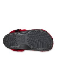 Zwarte en rode slipperzool met een gestructureerd grippatroon. De rubberen onderkant heeft verheven secties voor grip en duurzaamheid.