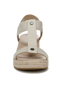 Beige espadrille sandal with woven upper, wide straps, and a platform jute sole. Features a central accent button on the strap.
