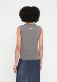 Top gri fără mâneci din tricot, cu tiv și decolteu nervurat. Are logo-ul "2ND" cusut pe spate. Textură netedă și design mulat.