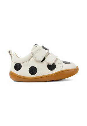 Witte peuterschoen met zwarte stippen, twee klittenbandsluitingen en een bruine rubberen zool, weergegeven in linkervoorzijde op een witte achtergrond.