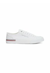 Zapatillas de lona blancas con un diseño de caña baja, que cuentan con ojales plateados, cordones blancos y un acento a rayas negras y rojas en la suela.
