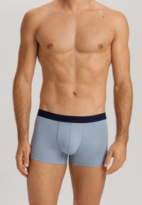 Ljusblå boxertrosor i mjukt material med midjeband i marinblått som har pr präglad branding. Kroppsnära design och slät yta.