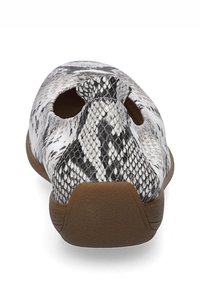 Zapato de piel con impresión de serpiente en blanco y negro, con un diseño cortado, puntera redondeada y suela de goma color tostado. La vista trasera muestra detalles de estilo únicos.