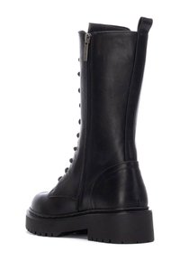 Botas de cuero negro hasta la mitad de la pantorrilla con punta redonda, cremallera lateral y cordones en la parte delantera. Suela de goma gruesa con agarre texturizado para mayor estabilidad.