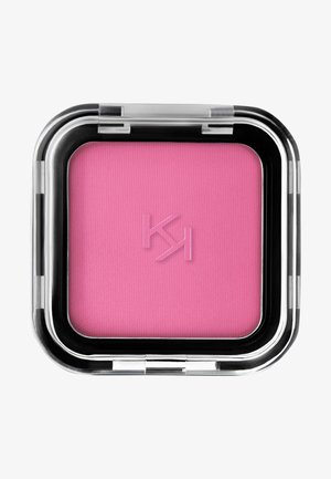 Quadratisches Rouge-Compact mit klarem Kunststoffgehäuse. Heller rosa Puder mit strukturierter Oberfläche. Verfügt über ein geprägtetes Logo auf dem Puder.