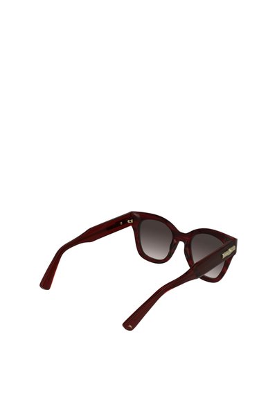 Rode acetaat kattenoogzonnebril met gradiënt grijze lenzen en gouden accenten op de tempels. Bevat dikke pootjes en een subtiel textuurpatroon.