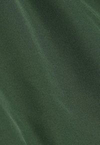 Tessuto verde scuro con una superficie liscia e texturizzata e una trama uniforme, adatto per vari usi tra cui abbigliamento e tappezzeria.