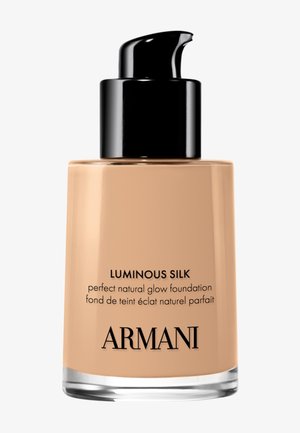 Botella de base Armani Luminous Silk con dosificador negro y maquillaje líquido beige en su interior.