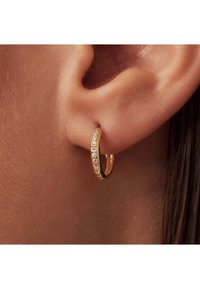 Gold hoop earring featuring a row of small, clear crystals along one edge. Smooth surface and round shape designed for pierced ears.