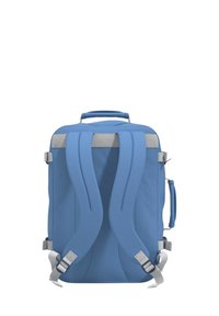 Zaino blu con spallacci grigi regolabili, maniglia superiore e compressioni laterali. Caratterizzato da un design elegante e rettangolare e da un tessuto testurizzato.