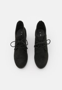 Czarne zamszowe botki za kostkę z zaokrąglonym noskiem, wiązane z przodu, o minimalistycznym designie. Gładka faktura i płaska gumowa podeszwa. Rozmiar 37.