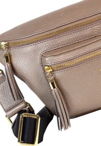 Borsa a tracolla in pelle beige con zip e accessori dorati. Presenta due scomparti con cerniera, frange decorative e una tracolla regolabile.