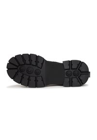 Suela de goma negra con un patrón de banda de rodadura profundo, que presenta lóbulos de tracción circulares y una sección suave en el centro, diseñada para ofrecer agarre y durabilidad.