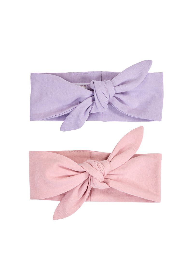 Kaksi solmittua kangaspäähinettä, yksi laventelinvärinen ja toinen vaaleanpunainen, asetettu vaakasuoraan valkoiselle taustalle.