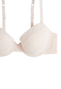 Soutien-gorge rose clair avec texture à pois, dentelle sur les bonnets, bretelles réglables et soutien-gorge à armatures. Fini en tissu lisse et forme structurée.