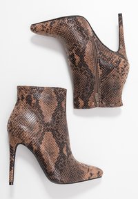 Stivaletti alla caviglia con stampa pitone marrone e nera, dotati di un elegante tacco a stiletto e chiusura lampo laterale. Texture liscia con design a punta.