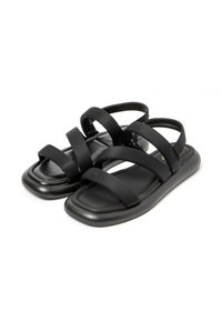 Black flat sandals with four wide fabric straps, a smooth matte finish, and a squarish toe shape. Lightweight and minimalist design.