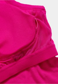 Sport-BH i en livlig rosa färg, med en slät textur, meshpaneler och en bred elastisk kant för stöd.