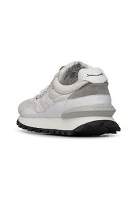 Sneaker bianco con una combinazione di pelle liscia e morbida suede grigia. Presenta una suola testurizzata, punta rotonda e un accento di marca sul tallone.