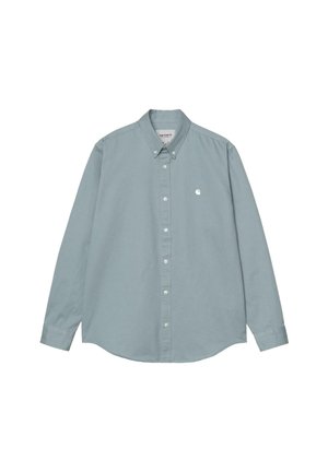 Camisa de manga larga azul claro hecha de algodón, con un cuello abotonado, una tapeta frontal y un pequeño logo en el lado izquierdo del pecho.