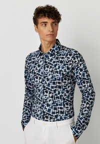 Langärmliges Hemd mit Knopfleiste in Marineblau mit einem geometrischen weißen Muster. Verfügt über einen klassischen Kragen und geknöpfte Manschetten, aus leichtem Stoff gefertigt.