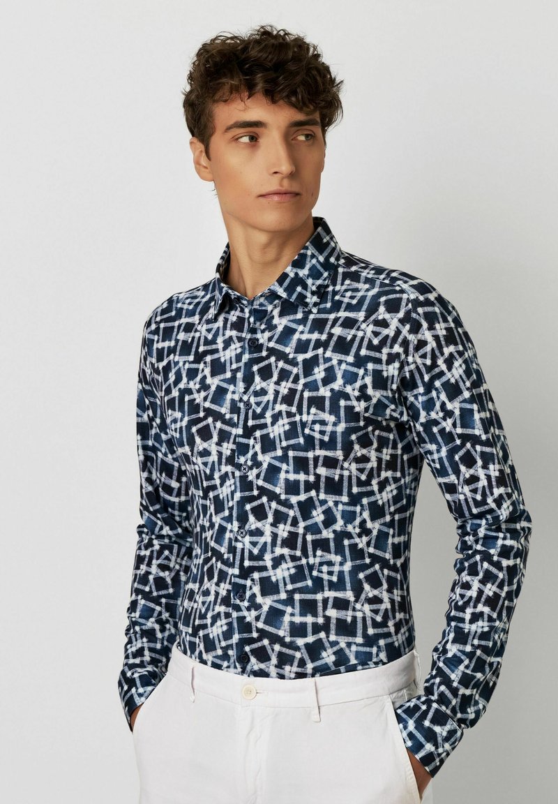 Langärmliges Hemd mit Knopfleiste in Marineblau mit einem geometrischen weißen Muster. Verfügt über einen klassischen Kragen und geknöpfte Manschetten, aus leichtem Stoff gefertigt.