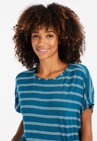 Mėlynas trumpomis rankovėmis marškinėliai su baltomis horizontaliomis juostelėmis, turintys apvalų iškirpimą ir švelnią, lygią tekstūrą. Be išskirtinių detalių ar akcentų.