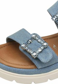 Denim slide sandal med en beige innersula och textilmaterial. Utrustad med en silverfärgad spänne dekorerad med klara rhinestones och en vadderad plattformssula.