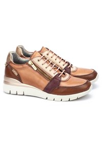 Zapatillas de cuero marrón y beige que presentan un diseño texturizado, un detalle de cremallera dorada y una suela blanca acolchada. Forro transpirable.