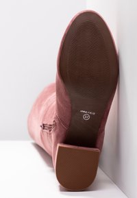 Botte en daim rose avec talon carré texturé, fermeture éclair latérale et semelle ondulée marquée "Anna Field 37" pointure.