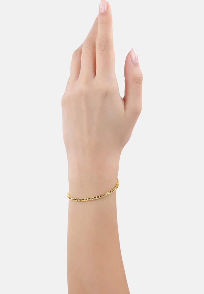 Pulsera de color dorado con un diseño retorcido, reposando sobre una mano. Textura suave y perfil delgado. Acento de metal brillante que destaca.