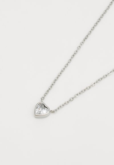 Collier en argent avec un pendentif en forme de cœur, doté d'un centre en pierre précieuse transparente et d'une bordure en métal poli.