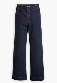 Jeans de mezclilla de pierna ancha en azul oscuro con costuras naranjas, bolsillos frontales y cinturilla con botones.
