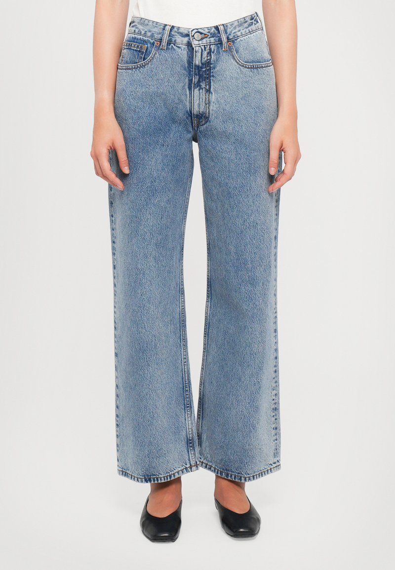 Wide-leg blue denim jeans with a faded finish, high waist, and classic five-pocket design. Features a button fly and straight cut.