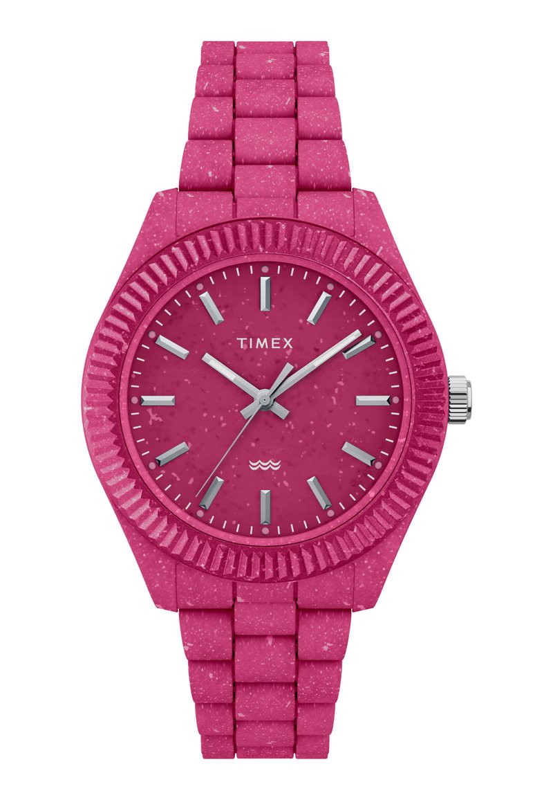 Reloj Timex rosa con correa de silicona texturizada, esfera redonda, bisel estriado, marcadores de hora plateados y agujas a juego. Diseño resistente al agua.