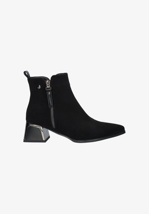 Botas de tobillo de ante negro con punta afilada y cremallera lateral. Cuentan con un tacón de bloque metálico y una tira en la parte trasera.