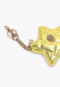 Pochette gialla a forma di stella realizzata in materiale metallico trapuntato, con una catena dorata con chiusura e un accento decorativo in gemma.