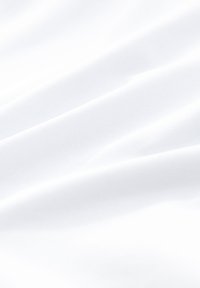 Tessuto bianco con una texture liscia, caratterizzato da morbide pieghe e una leggera lucentezza. Il materiale sembra leggero e arioso.