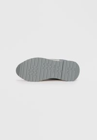 Calvin Klein sneakers with a grey rubber sole, featuring a textured surface, patterned treads, and subtle branding detail.