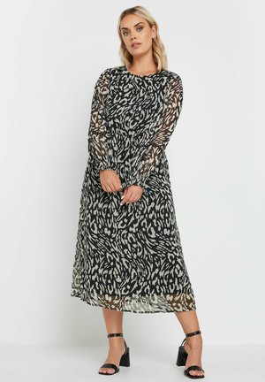 Zwart-wit gestreepte lange mouw jurk met een doorzichtige overlay en een geknikt taille, met een slim fit en een lengte tot halverwege de kuit.